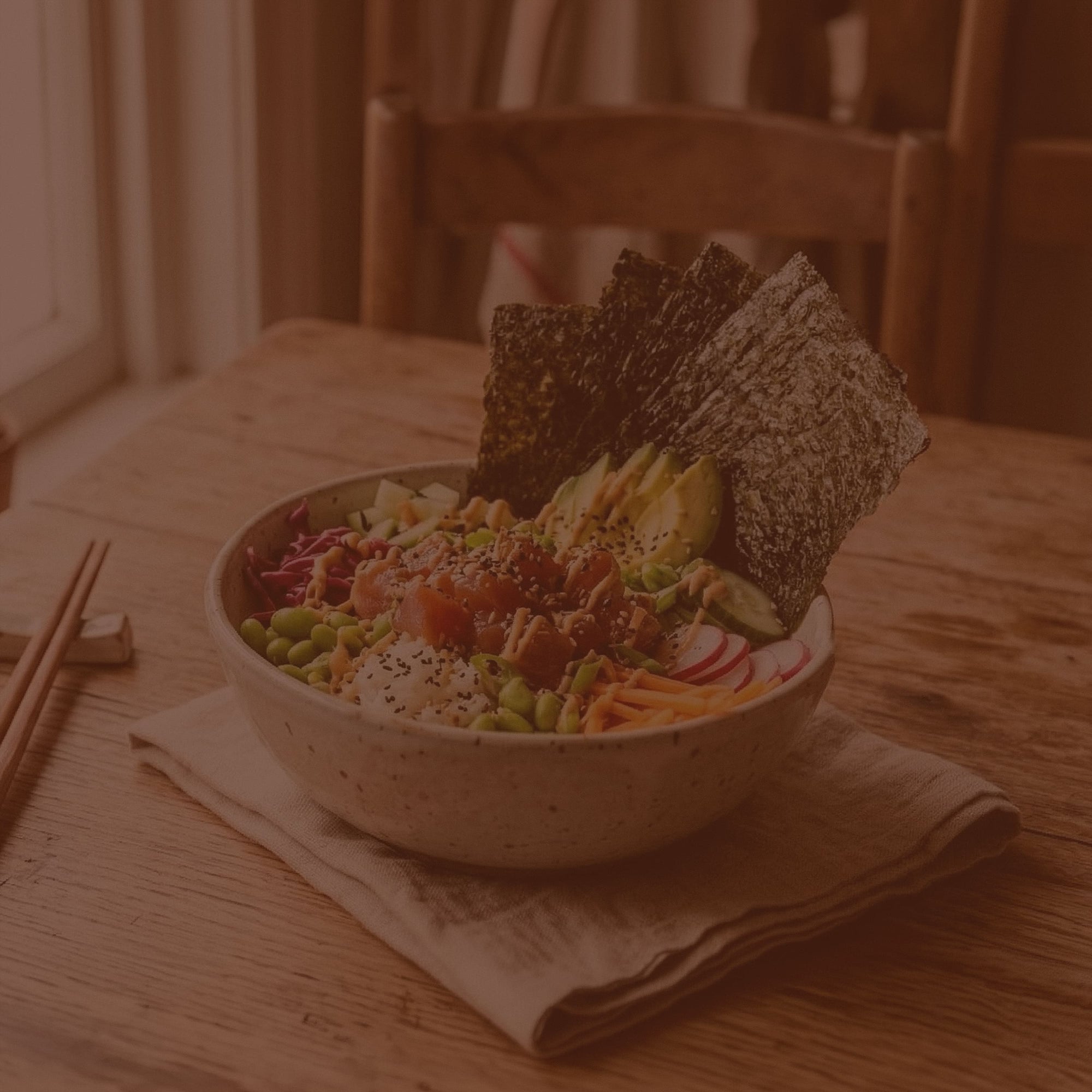 Bowl of salad with crackers on a wooden table